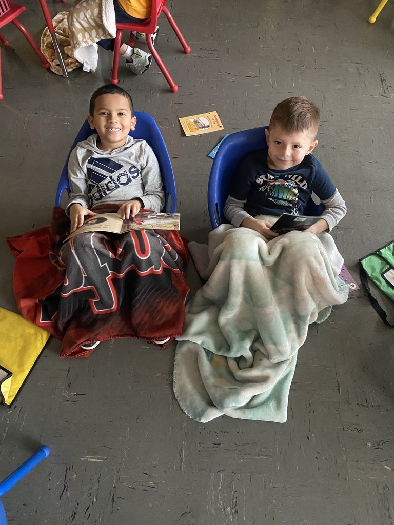 DBO picture of multiple students, laying down on the carpet, sitting on chairs and also with cozy blankets  1st graders sure do enjoy their cozy reading time!!! 