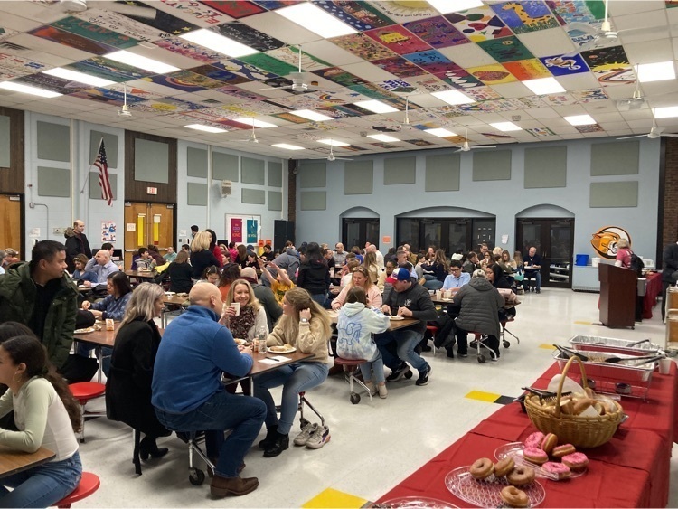 Great day honoring our student recipients of the CMS Citizenship Award. Thank you to our students and families for a special day. Parents and Students seating at the cafeteria tables eating snacks , table with snacks also pictured with donuts, muffins 