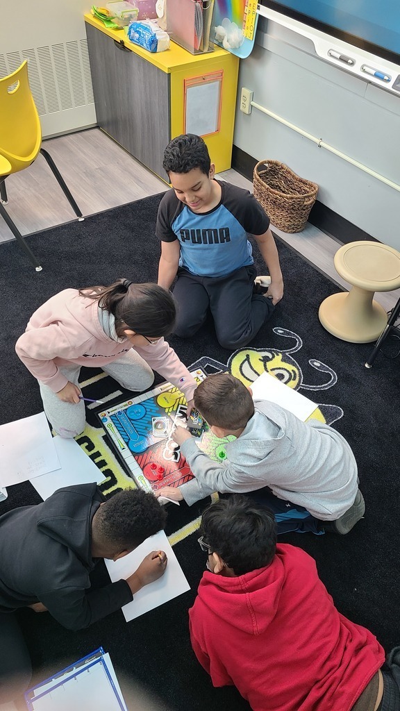 Picture of five students on the carpet playing board games