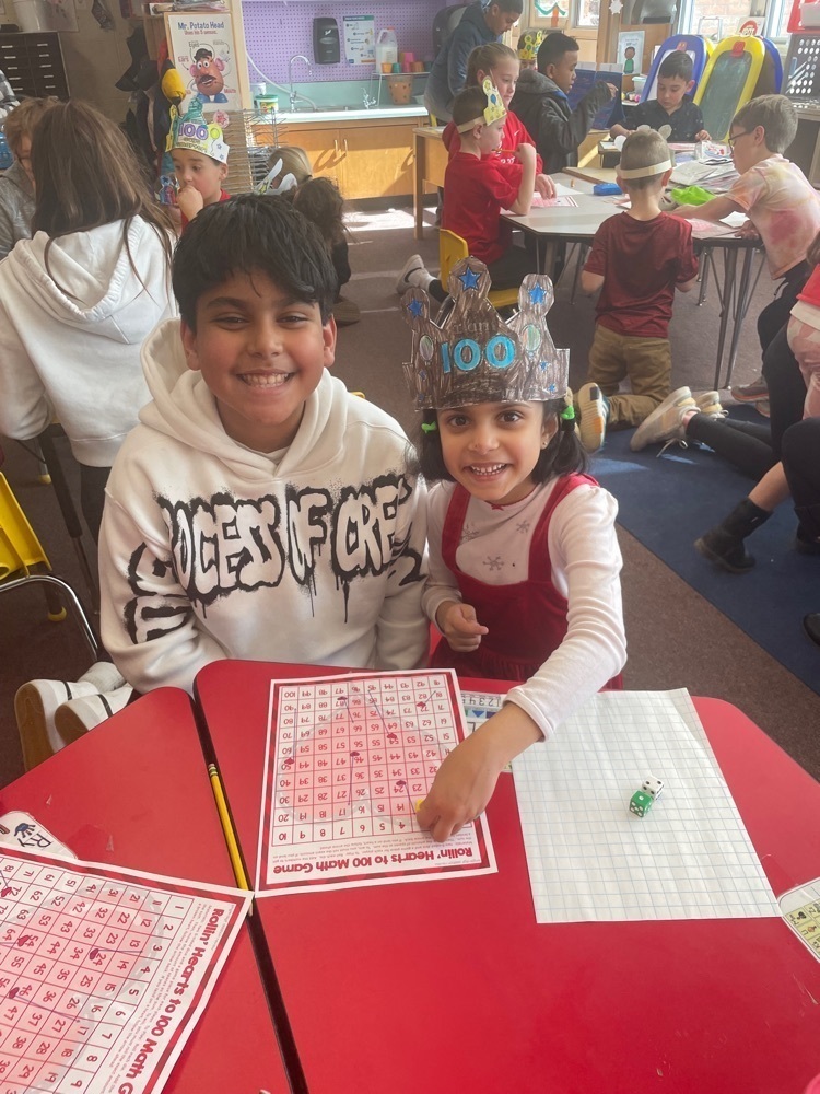 Photo of two students sitting on the table crafting Kindergarten celebrated the 100th day of school with their 5th grade buddies. #SBhasHEART