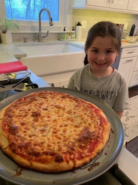 photo of student posing with her homemade pizza
